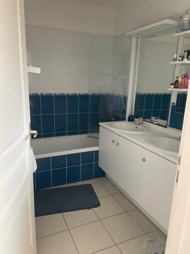La salle de bains est pourvue d'une baignoire, d'un lavabo, d'une baignoire et d'un miroir. dans l'établissement Appartement à Soulac-sur-mer, Résidence Villa Marine, à Soulac-sur-Mer