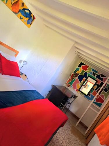 a bedroom with a bed and a desk with a painting on the wall at Hotel Marrokos Aeropuerto José María Córdova in Rionegro