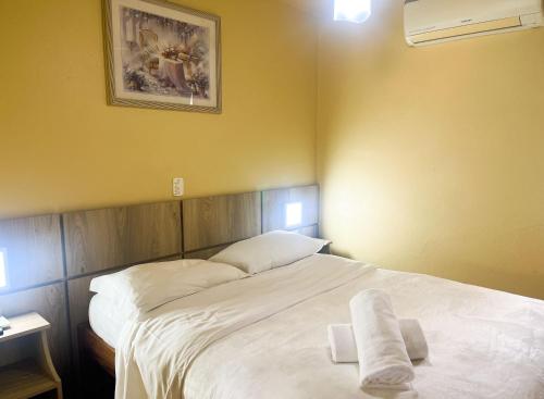 a bedroom with a large bed with two towels on it at Pousada Drehmer Haus in Gramado