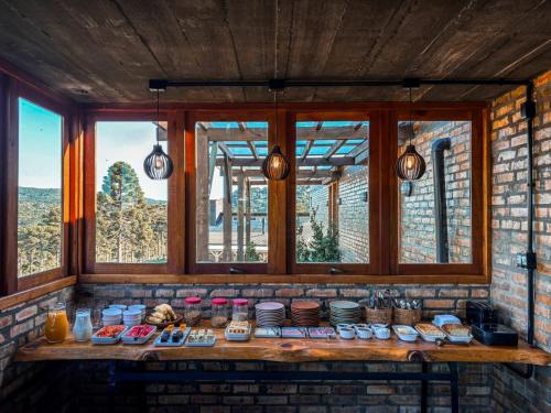 a counter with food on it in a room with windows at Monte Sião Château in Urubici
