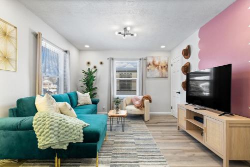 a living room with a blue couch and a tv at Game Room Retreat with Firepit and Gym, Sleeps 12 in Indianapolis