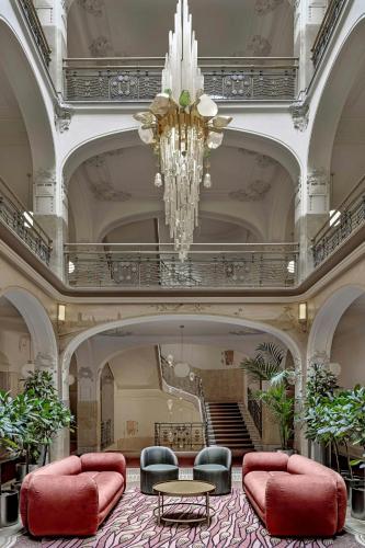 a large lobby with a chandelier and red furniture at W Prague in Prague