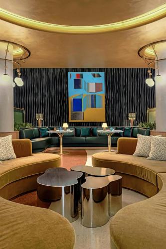 a lobby with couches and tables and a painting at W Prague in Prague