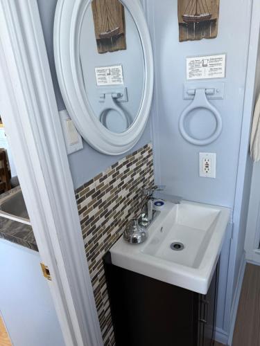 ペルセにあるMotel le reposの洗面台と2つの鏡があるバスルーム