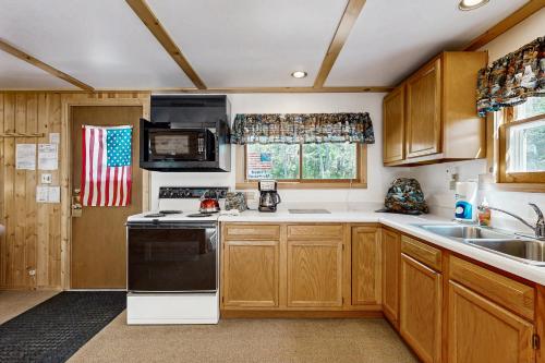 a kitchen with wooden cabinets and a black and white appliance at Quaint Lake Escape in Eagle River