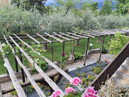 a wooden pergola in a garden with flowers at Σπίτι στο κυμα in Litochoro