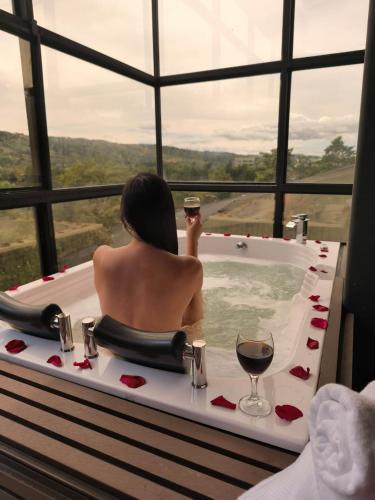 a woman in a bath tub with a glass of wine at Medellin cerca al aeropuerto Rionegro Antioquia in Rionegro