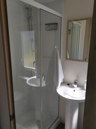a bathroom with a glass shower and a sink at Nikola in Skegness