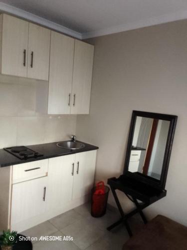 Una cocina con un espejo, un fregadero y una silla. en Corporate or Contractors Beautiful Aerorand Apartment, en Middelburg