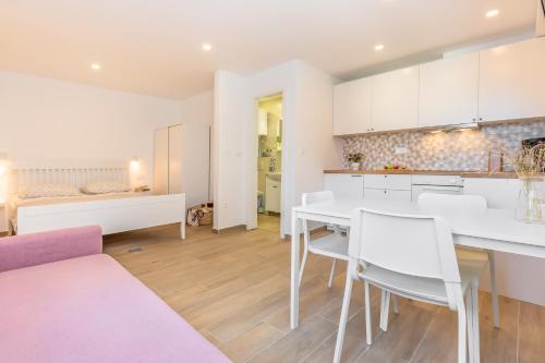 une cuisine et un salon avec une table et des chaises blanches dans l'établissement Sole Mio, à Celina