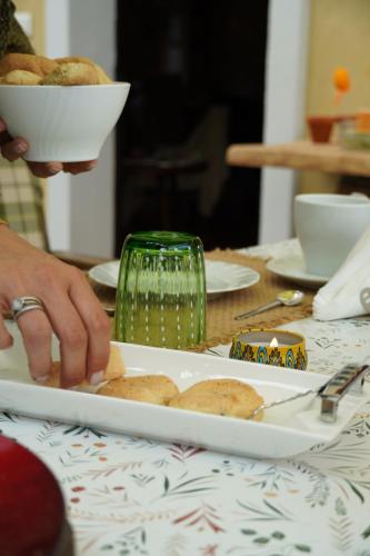 una persona que alcanza un plato de comida en una mesa en La Casa del Glicine Tarzo, en Fratta