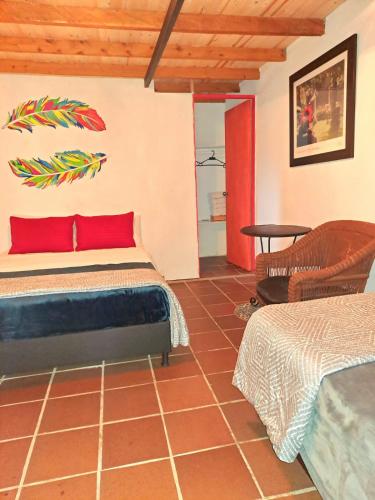 a bedroom with a bed and a chair in a room at Hotel Marrokos Aeropuerto José María Córdova in Rionegro