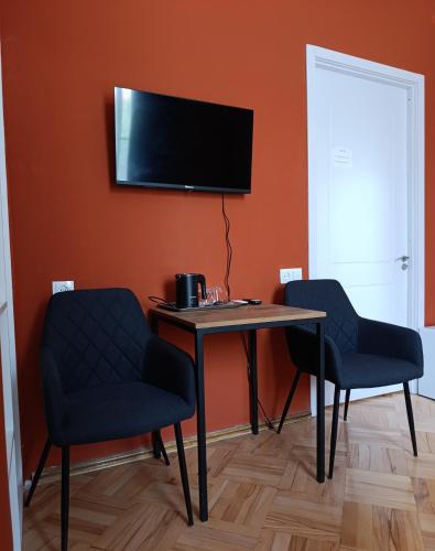 a room with a table and two chairs and a television at Guest House Top Floor in Tʼelavi