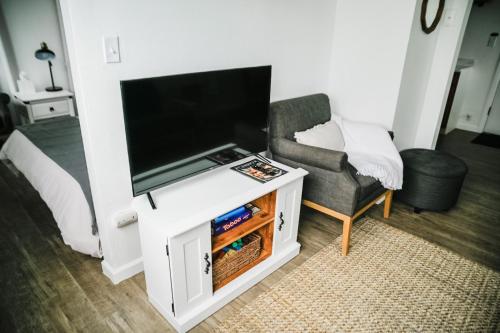 a living room with a flat screen tv and a chair at House-1 Bedroom, 1 Bath-Private, Centrally Located in Kalispell