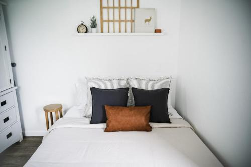 a bedroom with a white bed with a orange pillow at House-1 Bedroom, 1 Bath-Private, Centrally Located in Kalispell