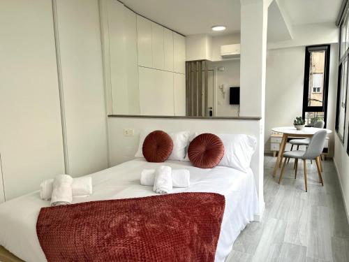 a bedroom with a bed with white sheets and red pillows at Luxury in the centre of Murcia in Murcia