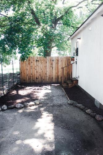 a wooden fence next to a house with a tree at House-1 Bedroom, 1 Bath-Private, Centrally Located in Kalispell