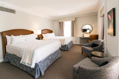 um quarto de hotel com uma cama grande e duas cadeiras em The Tidewater Inn em Easton