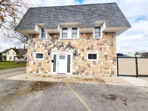 a stone house with a white door on a street at Charlies by the Bay Unit 4 in New Baltimore