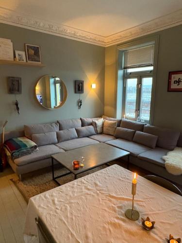 a living room with a couch and a table at Staymate 15 minutes from Barcode in Oslo