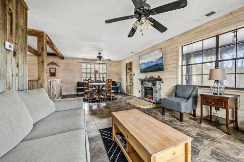 a living room with a couch and a ceiling fan at Grassy Paradise by Avada Properties in Sevierville