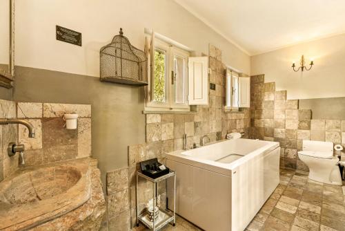 a bathroom with a tub and a toilet and a sink at I Capricci Di Merion - Resort & Spa in Tuoro sul Trasimeno