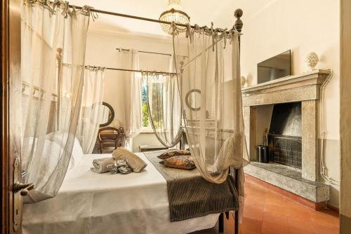 a bedroom with a canopy bed and a fireplace at I Capricci Di Merion - Resort & Spa in Tuoro sul Trasimeno