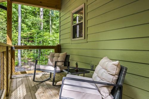 a green house with two chairs on a porch at Smoky Mtns Private w/Hot Tub, Game Room, Pets Free in Sevierville