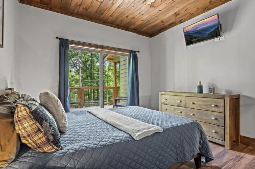 a bedroom with a bed and a dresser and a window at Smoky Mtns Private w/Hot Tub, Game Room, Pets Free in Sevierville