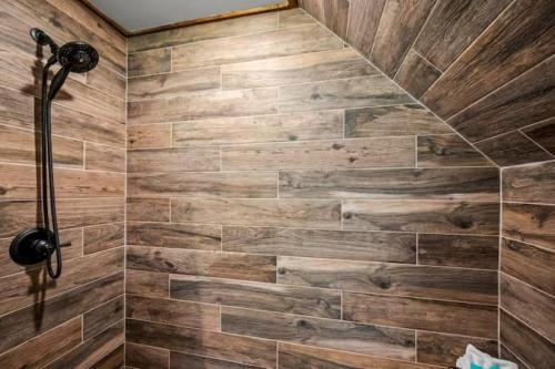 a bathroom with a shower with wooden walls at Smoky Mtns Private w/Hot Tub, Game Room, Pets Free in Sevierville