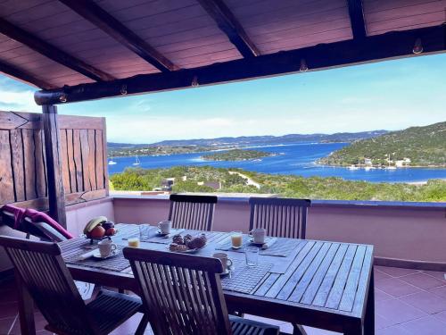 a table on a balcony with a view of a lake at Sea Cottage overlooking Seagull Island in Porto Rafael