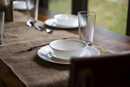 a table with plates and glasses on a wooden table at Smoky Mtns Private w/Hot Tub, Game Room, Pets Free in Sevierville