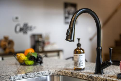 a kitchen counter with a sink and a bottle of wine at Smoky Mtns Private w/Hot Tub, Game Room, Pets Free in Sevierville