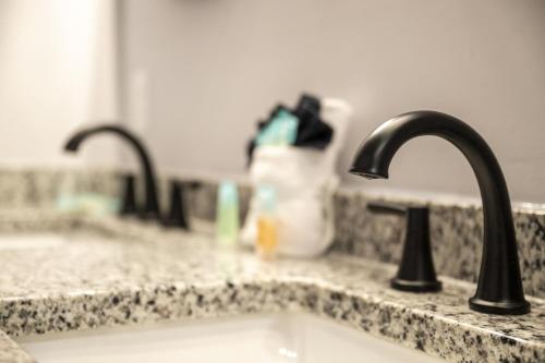 a kitchen sink with two faucets on a counter at Smoky Mtns Private w/Hot Tub, Game Room, Pets Free in Sevierville