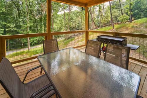 a screened in porch with a table and a grill at Smoky Mtns Private w/Hot Tub, Game Room, Pets Free in Sevierville