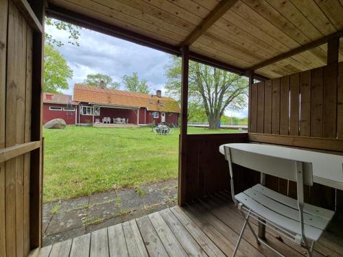 a screened in porch with a bench and a barn at Morgonljus B&B-edith&julia-Self check-in in Rälla
