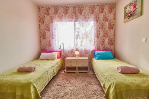 two twin beds in a room with a window at Cozy 3-BD Villa Natalia, Walk to Beach in Paphos