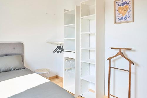 une chambre avec un lit et une étagère dans l'établissement L'Infini Choletais - Netflix et Climatisation, à Cholet