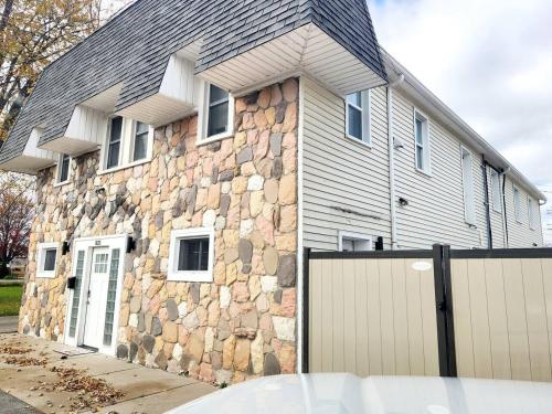 a stone house with a fence in front of it at Charlies by the Bay Unit 1 in New Baltimore