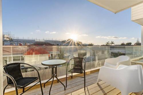 a balcony with two chairs and a table on a roof at Premium Sunset Townhouse with 6 Aircons near Airport in Auckland