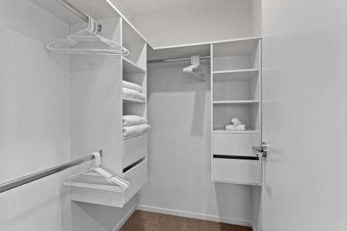 a walk in closet with a door and shelves at Premium Sunset Townhouse with 6 Aircons near Airport in Auckland