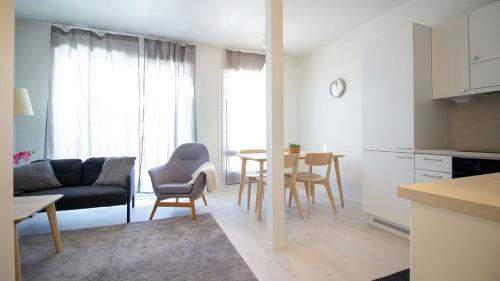 a kitchen and living room with a table and chairs at Convenient Apartment for 4 with Sauna in Espoo