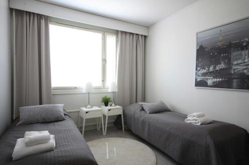 a bedroom with two beds and a window at Spacious Apartment for 6 in Espoo