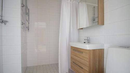 a bathroom with a sink and a shower with a shower curtain at Spacious Apartment for 6 in Espoo
