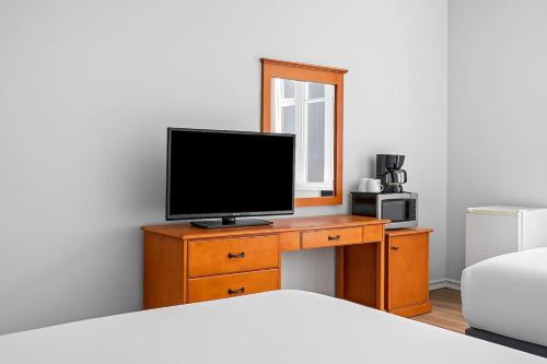キャンモアにあるPerfect Canmore Getaway for 4 plus Exclusive Savingsのベッドルーム(ベッド1台、ドレッサー内のテレビ付)