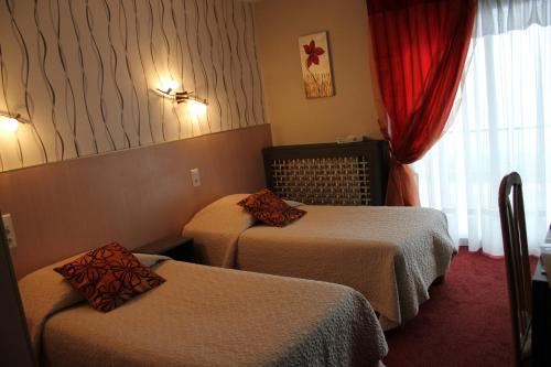 a hotel room with two beds and a window at Hôtel Restaurant le Panorama in Évian-les-Bains