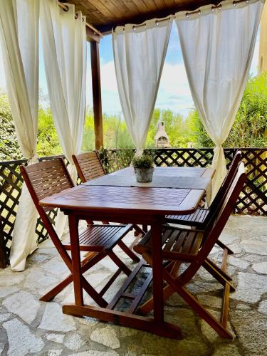 a wooden table and two chairs on a patio at SoNi Home in Viddalba