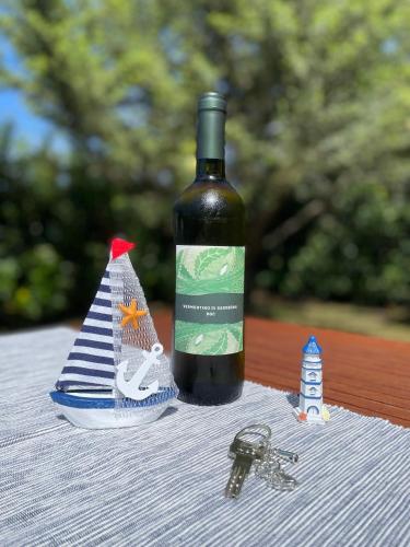 a bottle of wine with a toy boat and keys at SoNi Home in Viddalba