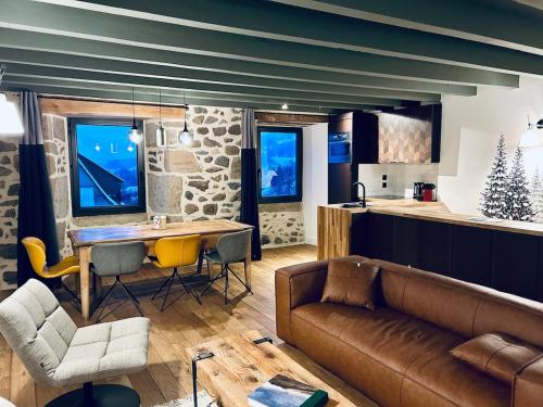 een woonkamer met een bank en een tafel bij Maison cosy avec sauna en montagne in Saint-Jacques-des-Blats