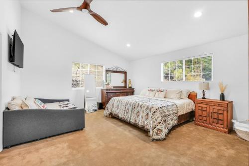 une chambre avec un lit, un canapé et un ventilateur dans l'établissement Scape to the Ranch - Relax, Work or Explore, à Castro Valley